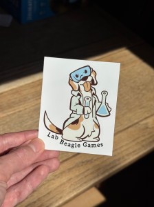 Picture of our mascot, Butternut, as a lab beagle sticker for Lab Beagle Games. She's ready to do science!